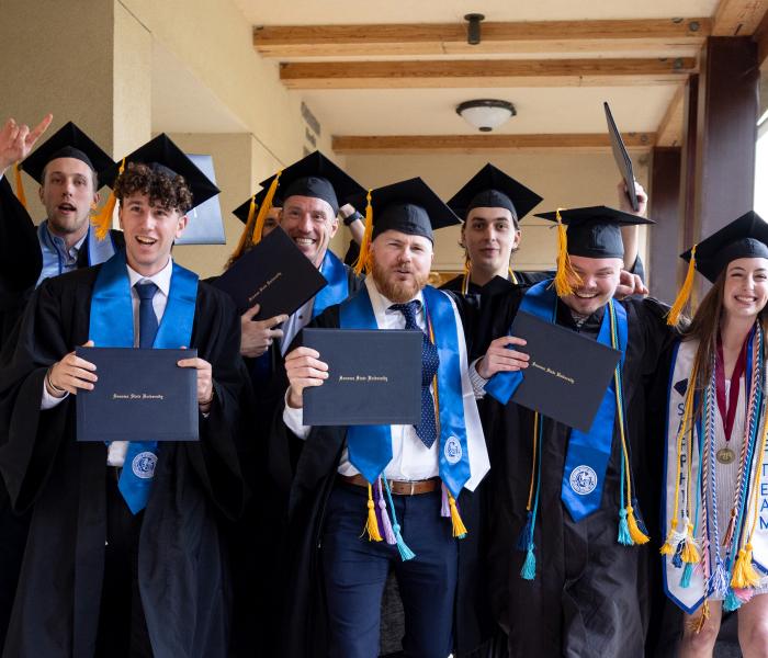 A group of happy graduates holding their diplomas