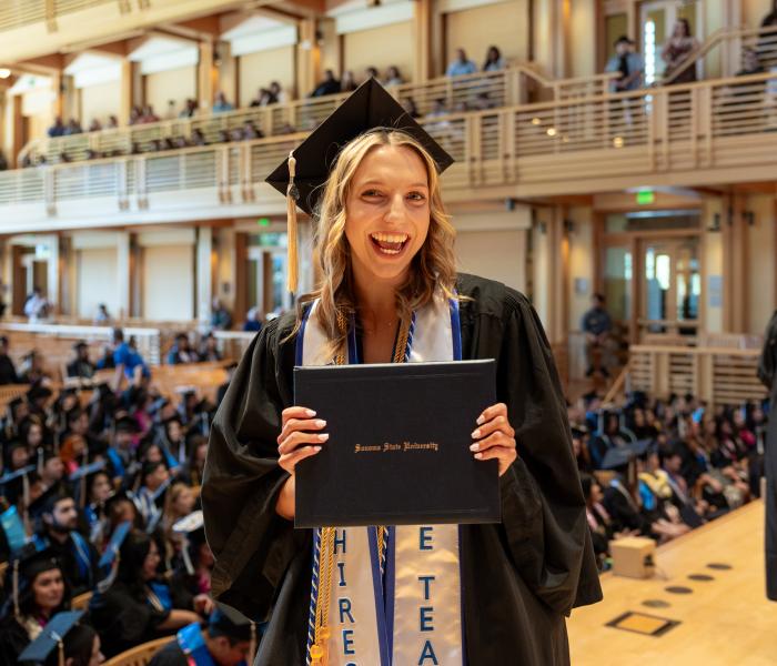 Student holding diploma at commencement