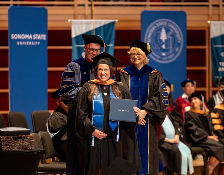 Faculty and student on stage