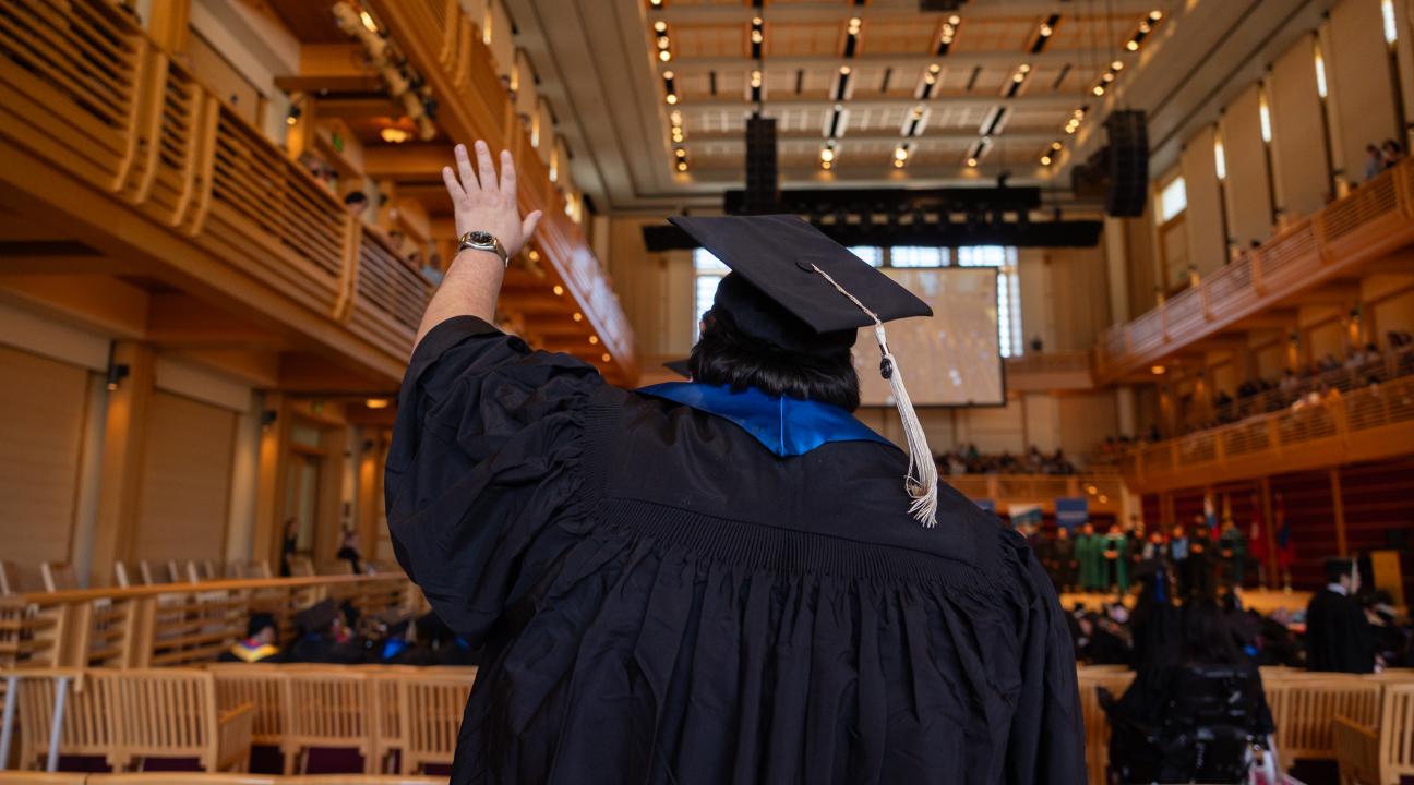 Student raising hand while entering the GMC
