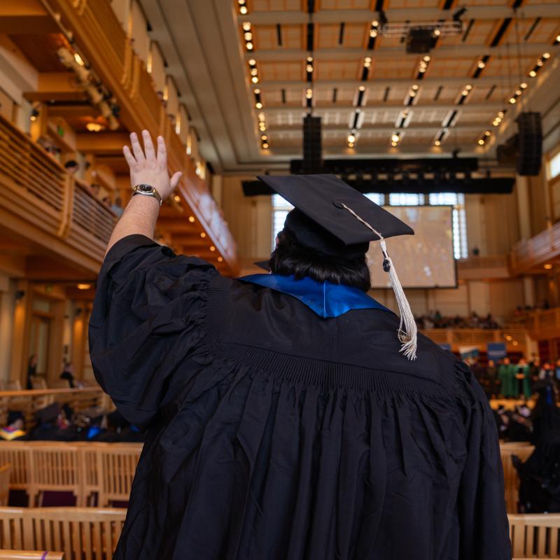Student raising hand while entering the GMC