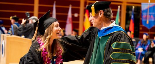 Graduate congratulated by faculty member