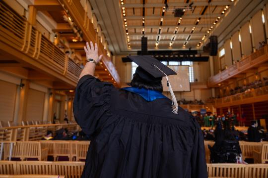 Student raising hand while entering the GMC