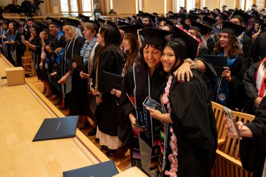Students hugging after graduating