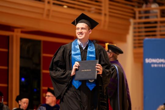 graduate walking across the stage